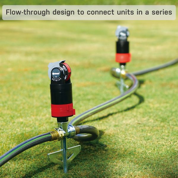 Two irrigation system filters with adjustable dials are connected in a series on a grass field, with hoses attached, highlighting a flow-through design feature.