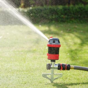 Eden 6-Pattern Rotary Gear Drive Sprinkler with Step Spike spraying water on to a green grass