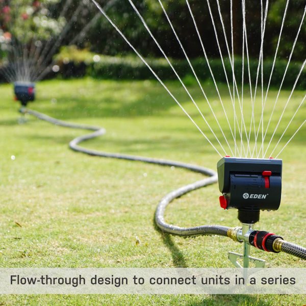 Multiple lawn sprinklers connected by hoses, spraying water across a green lawn. The foreground shows the "Eden" brand sprinkler with a label highlighting its design.