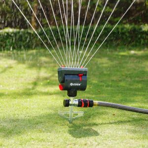 Eden Mini Oscillating Sprinkler with Step Spike shown watering a large, green lawn