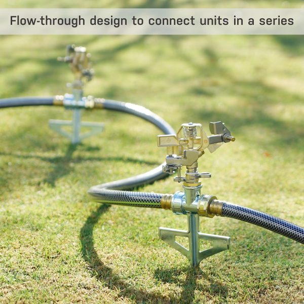 The image shows a close-up of a metal sprinkler or irrigation equipment with hoses attached, and it's positioned on a green lawn with text overlay describing a flow-through design.