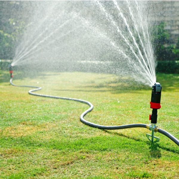 Three Metal Step Spike Bases with Flow Control Valves connected to Eden sprinkler heads watering a green lawn